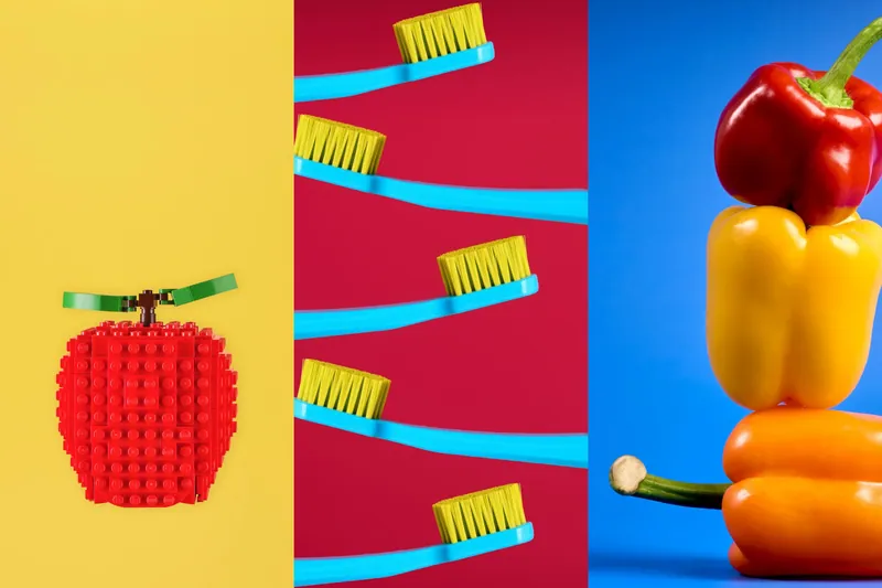 Tre still life pubblicitari: mela in mattoncini su giallo, spazzolini su rosso, peperoni su blu
