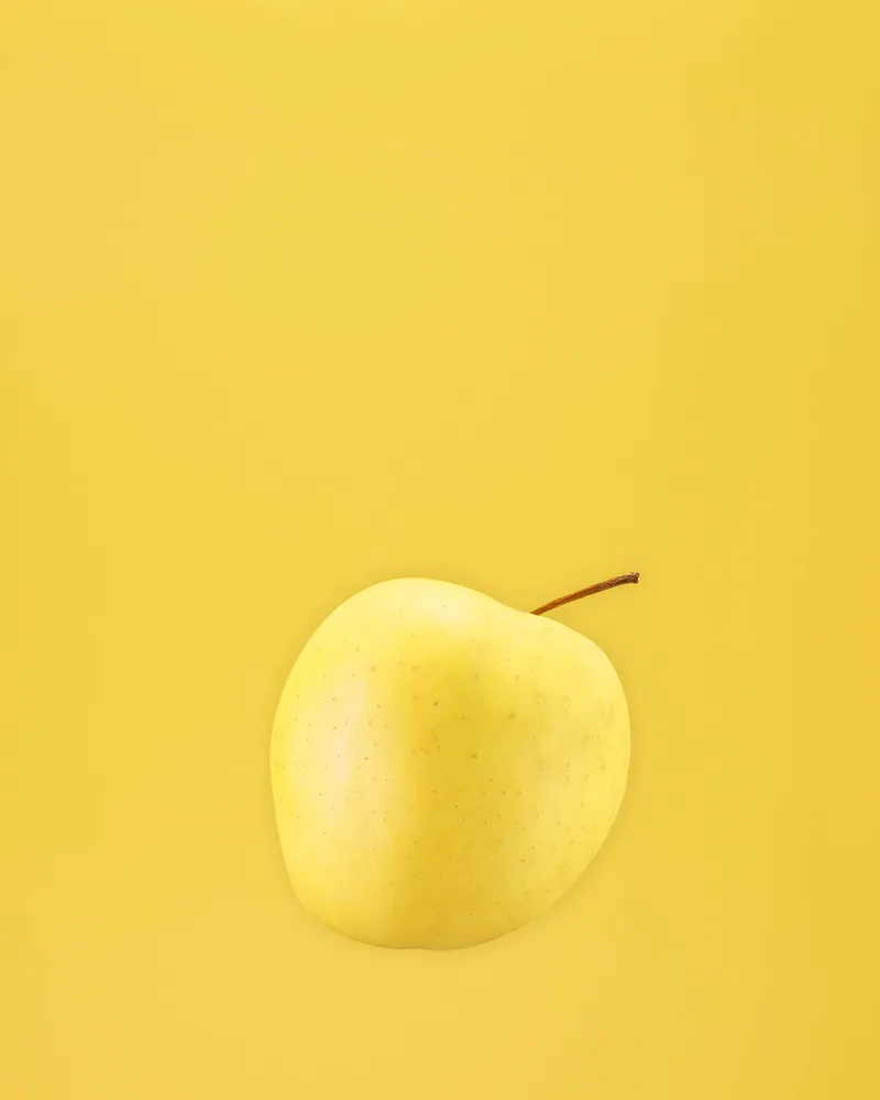 Mela gialla su fondale giallo, still life