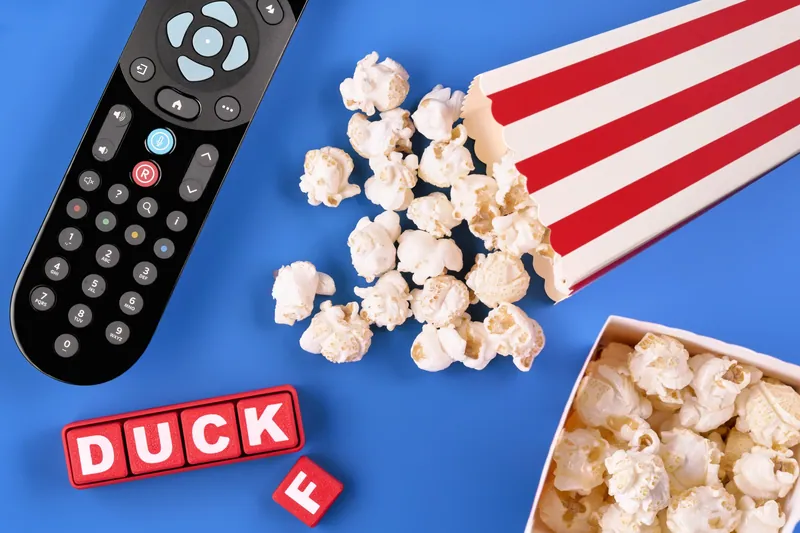 Pop corn, telecomando e lettere su fondale blu
