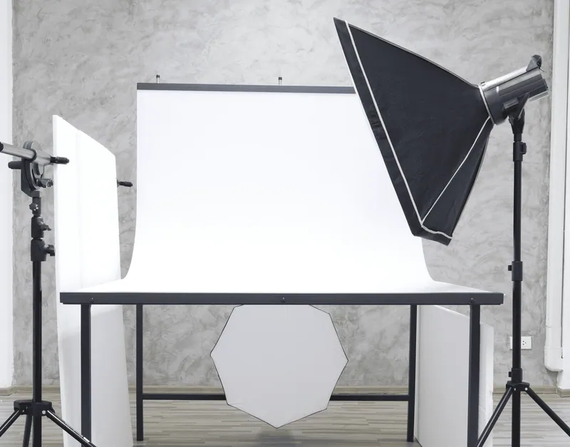 Studio con tavolo still life, sweep bianco e flash con softbox
