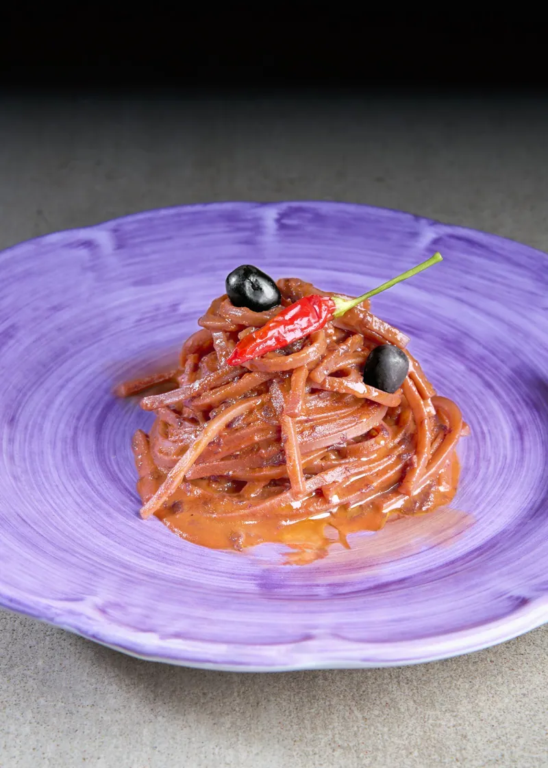 Spaghetti al pomodoro con peperoncino su piatto viola