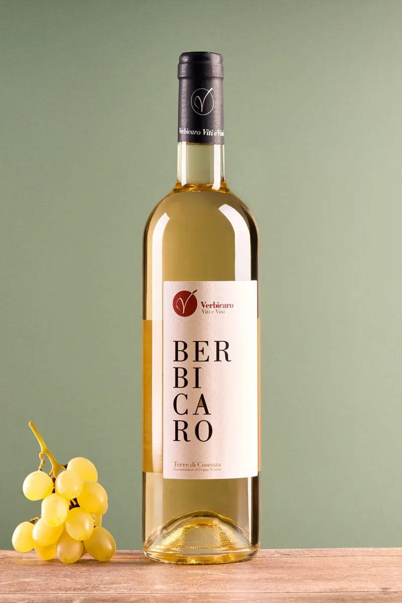 Bottiglia di vino bianco Berbicaro con uva su fondale verde
