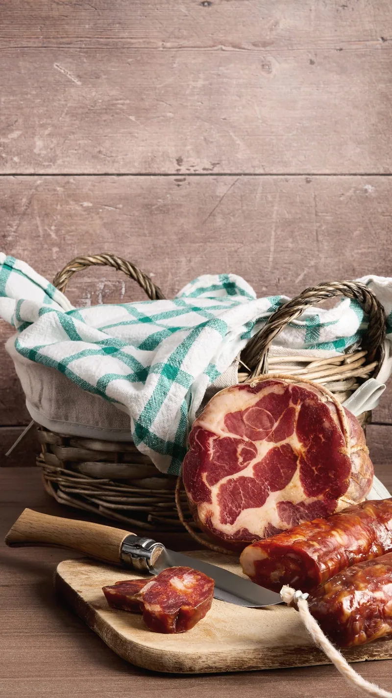 Salumi calabresi ambientati con cesto e tovaglia a quadri