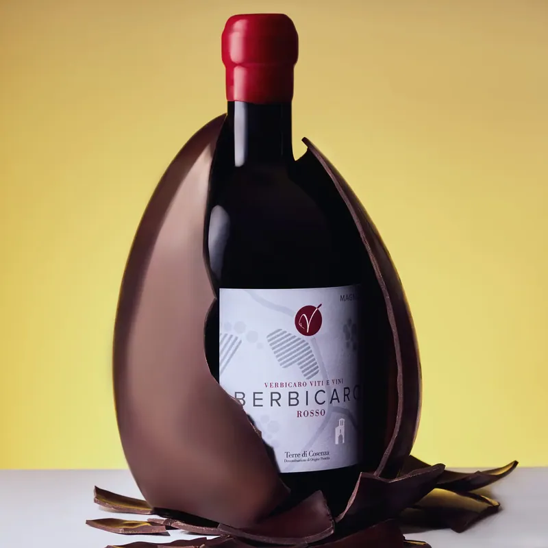 Bottiglia di vino che esce da un uovo di cioccolato, fondale giallo