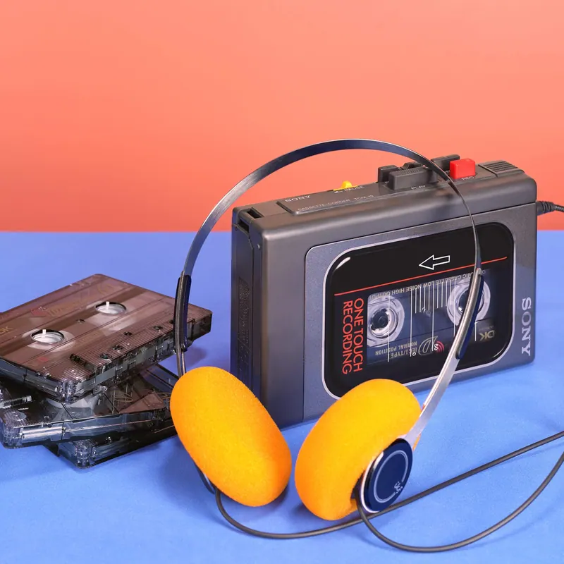 Walkman con cuffie e cassette su fondali rosa e azzurro